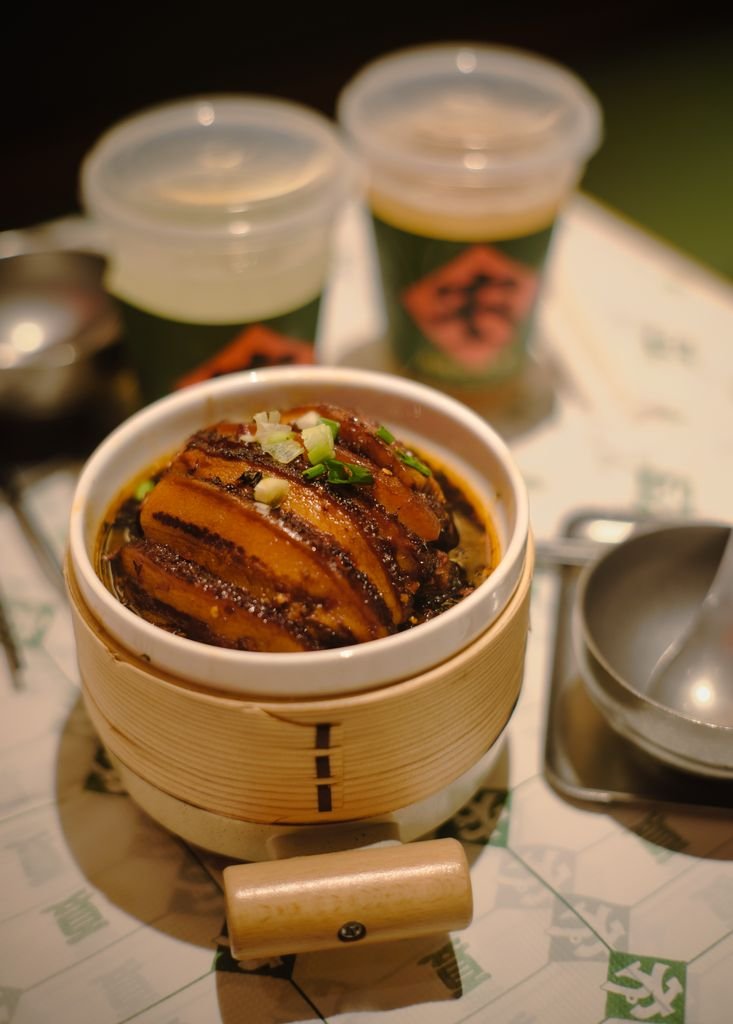 Savor the flavors of tender braised pork belly served in a traditional bamboo steamer.